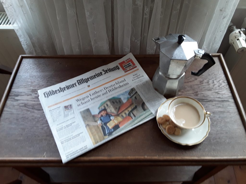 Stillleben: Eine Hildesheimer Zeitung, eine Tasse Kaffee, eine Kanne und einige Kekse